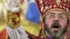 FILE - Armenian Archbishop Khajag Barsamian pours holy oil from a dove-shaped vessel during the Ceremony of the Blessing of the Water, during Christmas services.