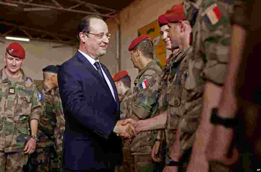 Presiden Perancis Francois Hollande menyalami pasukan Perancis saat tiba di markas operasi militer negaranya di bandar udara M'Poko di Bangui, Republik Afrika Tengah (28/2).