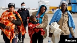 Migrants disembarks from Dattilo coast guard vessel in the Sicilian harbour of Augusta, Italy, Feb. 25, 2017.