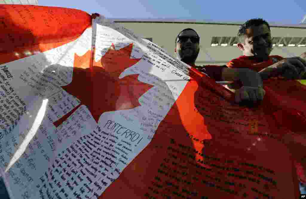 Canada's fans hold a flag before a group B match of the women's Olympic football tournament between Canada and Zimbabwe in Sao Paulo, Brazil, Aug. 6, 2016. 