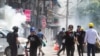 Polisi menembakkan gas air mata pada para demonstran saat mereka melarikan diri \, di Yangon, Myanmar, 8 Maret 2021. (Foto: Reuters)