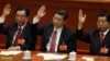 2012年11月14日资料照片：当时的中国国家副主席习近平（中）中央纪委贺国强（左）和中国人民政治协商会议主席贾庆林（右）在在北京人民大会堂举手批准工作报告