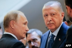 Ruski predsednik Vladimir Putin i turski predsednik Rečep Tajip Erdogan čekaju da uđu u stalu tokom njihovog sastanka u Sočiju, Rusija, 17. septebra 2018.