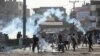 Supporters of the Tehreek-e-Labaik Pakistan (TLP) Islamist political party throwback tear gas canisters fired by police during a protest against the arrest of their leader in Lahore, Pakistan, Apr. 13, 2021. 