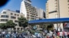 FILE - Scooter motorists queue for fuel outside a gas station in Lebanon's capital Beirut on June 29, 2021. 