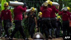 Thai soldiers carry oxygen tanks as rescue operations continue for the 12 boys and their football team coach trapped in Tham Luang cave at Khun Nam Nang Non Forest Park in the Mae Sai district of Chiang Rai province, July 7, 2018. More than 100 chimneys are being drilled into the mountainside in a frantic bid to reach a Thai youth football team trapped in a cave complex below, the head of the rescue mission said Saturday.