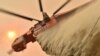 A helicopter drops fire retardent to protect a property in Balmoral, 150 km southwest of Sydney on Dec. 19, 2019. 