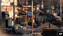 Soldiers of the government forces are seen outside a building in Attarib, Aleppo province, Syria, March 1, 2012.