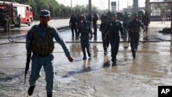 FILE - Afghan police soldiers inspect the site of a suicide attack in Kabul, Afghanistan, Monday, June 20, 2016.