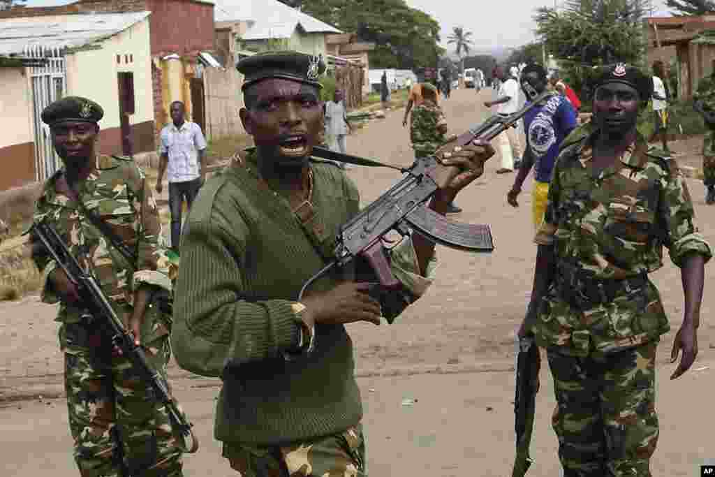 Des soldats tirent en l&#39;air pour disperser des manifestants qui ont acculé Jean Claude Niyonzima un membre présumé de la milice Imbonerakure de la jeunesse du parti au pouvoir dans un égout dans le quartier de Cibitoke de Bujumbura, au Burundi, jeudi 7 mai 2015.