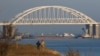 FILE - A Russian cargo ship is seen beneath a bridge connecting the Russian mainland with the Crimean Peninsula after three Ukrainian navy vessels were stopped by Russia from entering the Sea of Azov via the Kerch Strait in the Black Sea, Crimea, Nov. 25, 2018.