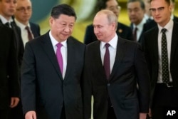 Presiden China Xi Jinping, kiri tengah, dan Presiden Rusia Vladimir Putin, kanan tengah, memasuki aula untuk pembicaraan di Kremlin di Moskow, Rusia, 5 Juni 2019. (Foto: AP)
