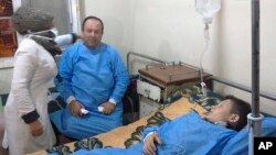 This photo released by the Syrian official news agency SANA shows people receiving treatment at a hospital following a suspected chemical attack on al-Khalidiya, in Aleppo, Nov. 24, 2018. 