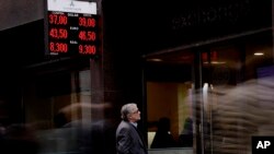 A man looks at the price of the U.S. dollar and Brazilian real at a money exchange house in Buenos Aires, Argentina, Monday, Sept. 3, 2018. Argentina's President Mauricio Macri has announced new taxes on exports and the elimination of several ministries on Monday in a bid to halt economic turmoil that has sent the peso to record lows.