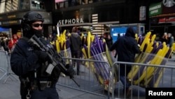 A member of the New York Police Department's Counterterrorism Bureau monitors security in Times Square ahead of New Year's celebrations in Manhattan, Dec. 29, 2017. 