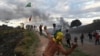 People hurl stones at the border between Santa Elena de Guairen, Venezuela, and Brazil in Pacaraima, Brazil, Feb. 23, 2019.