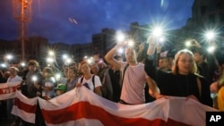 Para pendukung kelompok oposisi menyalakan lampu ponsel dalam unjuk rasa memprotes hasil pemilu di Lapangan Kemerdekaan, di Minsk, Belarusia, 20 Agustus 2020.