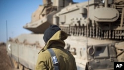 Seorang tentara Israel berdiri di sebelah tank di Dataran Tinggi Golan, dekat perbatasan Suriah, 28 November 2016. (Foto:Dok)