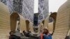 Sejumlah pekerja tampak beristirahat di luar sebuah pusat perbelanjaan di Beijing, China, pada 17 Januari 2024. (Foto: AP/Ng Han Guan)
