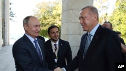 Russian President Vladimir Putin, left, and Turkish President Recep Tayyip Erdogan shake hands before their meeting in the Bocharov Ruchei residence in the Black Sea resort of Sochi, Russia, Oct. 22, 2019.