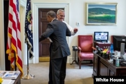 President Barack Obama celebrates the Supreme Court ruling on Affordable Care Act (ACA) subsidies, with Chief of Staff Denis McDonough in the Outer Oval Office. June 25, 2015. (Official White House Photo by Pete Souza)