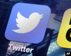 FILE - This Oct. 18, 2013, file photo, shows a Twitter app on an iPhone screen in New York.