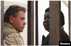 FILE - A combination photo shows Zimbabwean safari operator Honest Ndlovu (R) and fellow countryman and hunter Theo Bronkhorst waiting to appear in Hwange magistrates court, July 29, 2015.