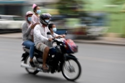 រូបឯកសារ៖ ពលរដ្ឋកម្ពុជាមួយគ្រួសារកំពុងធ្វើដំណើរតាមម៉ូតូ ដោយមានពាក់ម៉ាស់ នៅទីក្រុងភ្នំពេញ ថ្ងៃទី ២៨ ខែមេសា ឆ្នាំ២០២០។