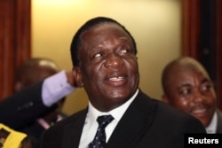 FILE - Newly appointed Zimbabwean Deputy President Emmerson Mnangagwa smiles at the headquarters of ZANU (PF) in Harare, Dec.10, 2014.