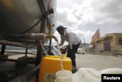 A man fills jerrycans with clean water from a donated source amid a shortage of water supply, in Yemen's capital Sanaa, April 14, 2016.