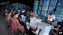 FILE - Afghan election workers sort ballots for an audit at an election commission office in Kabul, Afghanistan, Aug. 27, 2014. Abdullah has blamed Ghani for not moving swiftly on electoral reforms to prevent a repeat of the irregularities that marred the 2014 presidential poll.