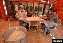 Relawan menyiapkan makanan untuk dibagikan kepada orang yang membutuhkan selama bulan suci Ramadhan, di Maan, Yordania 1 Mei 2021. (Foto: Reuters)