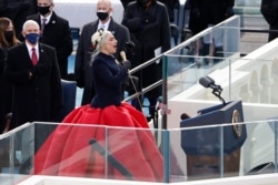 Lady Gaga dan Wakil Presiden AS Mike Pence saat penyanyi AS tersebut mengumandangkan Lagu Kebangsaan pada hari pelantikan Joe Biden sebagai Presiden ke-46 Amerika Serikat di Gedung Capitol, Washington, D.C., AS, 20 Januari 2021.