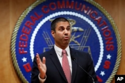 FILE - After a meeting voting to end net neutrality, Federal Communications Commission Chairman Ajit Pai answers a question from a reporter, Dec. 14, 2017, in Washington.