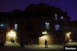 A man walks along a street at night in the old town of Kashgar, Xinjiang Uighur Autonomous Region, China, March 23, 2017. Thousands of "convenience police stations" have been built across Xinjiang. They are typically just hundreds of meters apart.