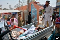 Volunteers rush injured persons to a hospital in Pakistan's southwestern city of Quetta, July 25, 2018, after a suicide bomber struck outside a crowded polling station.