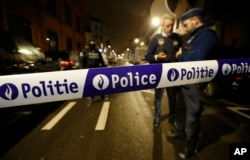 Police guard a check point during a police raid in the suburb of Schaerbeek in Brussels, March, 24, 2016.