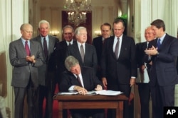 FILE - U.S. President Bill Clinton signs side deal of the three-nation North American Free Trade Agreement (NAFTA) at the White House, Washington, Sept. 14, 1993.