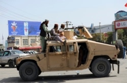 Pejuang Taliban berjaga di depan Bandara Internasional Hamid Karzai, di Kabul, Afghanistan, Senin, 16 Agustus 2021. (AP)