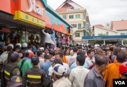 រូបឯកសារ៖ ប្រជាពលរដ្ឋ​មក​ចោមរោម​សព​លោក​កែម ឡី​ នៅ​ស្ថានីយ៍​ Caltex ​នៅ​រាជធានី​ភ្នំពេញ​ បន្ទាប់​ពី​លោក​ត្រូវ​បានខ្មាន់​កាំភ្លើង​បាញ់​សម្លាប់​នៅថ្ងៃ​អាទិត្យ​ ទី​១០ ខែ​កក្កដា​ ឆ្នាំ​២០១៦។ (ឡេង ឡែន/VOA)