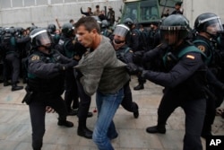 Civil guards clear people away from the entrance of a sports center, assigned to be a polling station by the Catalan government and where Catalan President Carles Puigdemont is expected to vote, in Sant Julia de Ramis, near Girona, Spain.