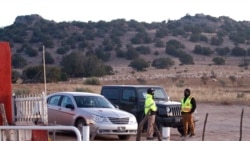 Security guards stand at the entrance to a film set where police say actor Alec Baldwin fired a prop gun, killing a cinematographer, outside Santa Fe, New Mexico, Oct. 22, 2021.