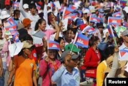 រូបឯកសារ៖ កម្មករ​រោងចក្រកម្ពុជា​ស្រែកហូ និង​ក្រវីទង់ជាតិ​ខ្មែរ នៅ​ពេល​ដែល​ពួក​គេ​ចូលរួម​ក្នុង​បាតុកម្ម​មួយ ដើម្បី​អំពាវនាវឲ្យ​រដ្ឋាភិបាល​តម្លើង​ប្រាក់​បៀរវត្សរ៍​ក្នុង​ក្បួន​ដង្ហែរ​ថ្ងៃទិវាពលកម្ម​អន្តរជាតិ​នៅ​ទីក្រុងភ្នំពេញ ថ្ងៃទី១ ខែ​ឧសភា ឆ្នាំ២០១៥។ (រូបថត៖ REUTERS/Pring Samrang)
