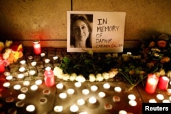 Candles burn to commemorate the killed investigative journalist Daphne Caruana Galizia in Berlin, Germany, Oct. 20, 2017.