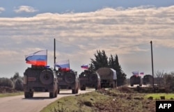 An image grab taken from AFP-TV on Jan. 17, 2019, shows Russian army vehicles on patrol in the area of Arimah, just west of Manbij, Syria, where a day earlier a suicide attack on a restaurant killed four U.S personnel.