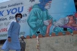 Papan bergambar petugas medis dan ucapan terima kasih atas pengabdian mereka dalam penanganan Covid-19 di Rawalpindi, 30 Juni 2020.