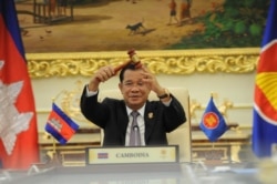 FILE - Cambodian Prime Minister Hun Sen holds the ceremonial gavel in a virtual meeting as Cambodia takes over the ASEAN chairmanship, from Brunei, for a third time, on Thursday, October 28, 2021. (Facebook/Samdech Hun Sen, Cambodian PM)