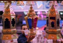 Seorang pria memeriksa lentera Ramadhan tradisional, yang disebut "fanous", di sebuah kios toko menjelang bulan suci Ramadhan, di tengah pandemi COVID-19 di Kairo, Mesir, 8 April 2021. (Foto: REUTERS/Mohamed Abd El Ghany)