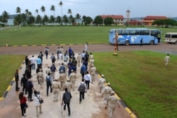 Cambodia naval personnel walk with journalists during a government organized media tour to the Ream naval base in Preah Sihanouk province on July 26, 2019.