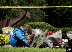 Gideon Murphy places a flower at the Tree of Life Synagogue in Pittsburgh, Sunday, Oct. 28, 2018.